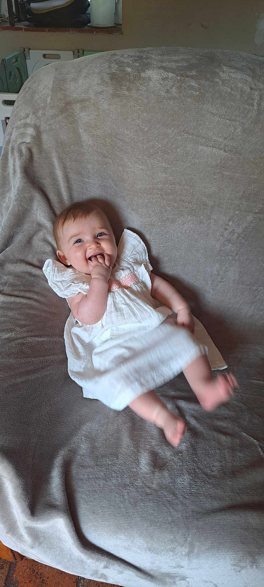 Léa a rejoint le concours — aidez-le/la à gagner de superbes lots ! baby, child, infant, smiling, white_dress, blanket, indoor, happy, cute, person, face, skin, fingers, feet, sitting, cozy, soft_texture, candid, young, playful