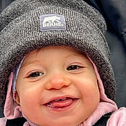 Oppie is registered to the contest to win money with this photo: baby, baby_clothing, child, child_face, close_up, cozy, cute, face, happy, hat, headwear, hoodie, infant, knit_hat, outdoor, person, pink_clothing, smiling, tongue_out, warm_clothing