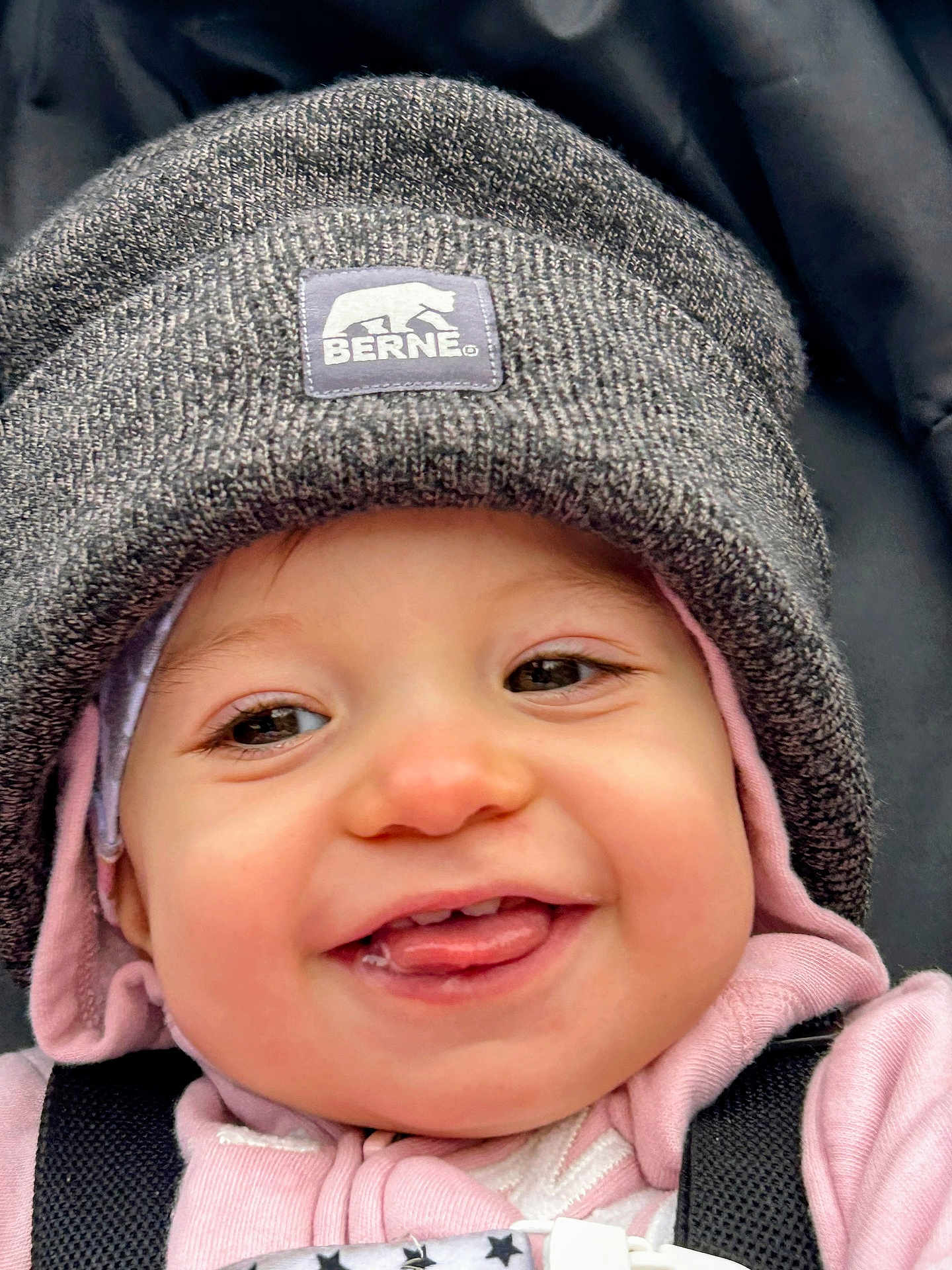 Oppie is registered to the contest to win money with this photo: baby, baby_clothing, child, child_face, close_up, cozy, cute, face, happy, hat, headwear, hoodie, infant, knit_hat, outdoor, person, pink_clothing, smiling, tongue_out, warm_clothing