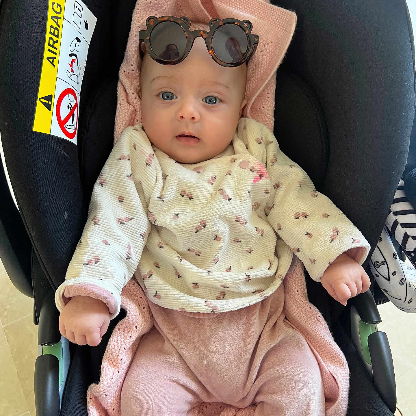 Victoire participe au concours pour gagner de l'argent avec cette photo : baby, car_seat, blanket, sunglasses, pink_clothing, sweater, infant, child, face, blue_eyes, cute, indoors, seat, knitted_blanket, person, apparel, cozy, fashion, adorable, portrait