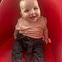 éléna participe au concours pour gagner de l'argent avec cette photo : baby, child, smiling, red_chair, pink_shirt, dark_pants, barefoot, sitting, cute, happy, indoor, face, person, infant, portrait, clothing, furniture, young_child, bright_color, casual_wear