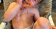 Mötley joined the competition — help win amazing prizes! toddler, child, high_chair, messy, food, smile, diaper, face, hand, arm, leg, hair, skin, happy, playful, indoor, seat, straps, expression, cute