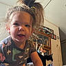 Mötley is registered to the contest to win money with this photo: toddler, child, indoor, person, cat, animal, hair, ponytail, shirt, dinosaur, furniture, cabinet, home, living_room, man, shirtless, curious, smile, portrait, pet
