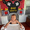 baby, high_chair, balloons, birthday, mickey_mouse, polka_dots, child, smiling, party, celebration, indoor, decorations, necklace, cute, toddler, face, expression, red, yellow, black