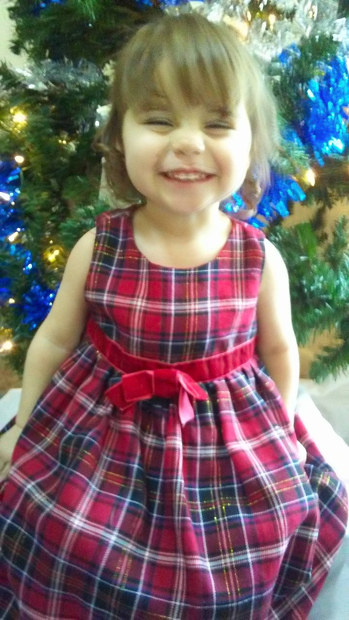 Vivian is registered to the contest to win money with this photo: child, child_model, christmas, clothing, design, dress, joy, pattern, person, plaid, smile, tartan, textile, toddler, tree