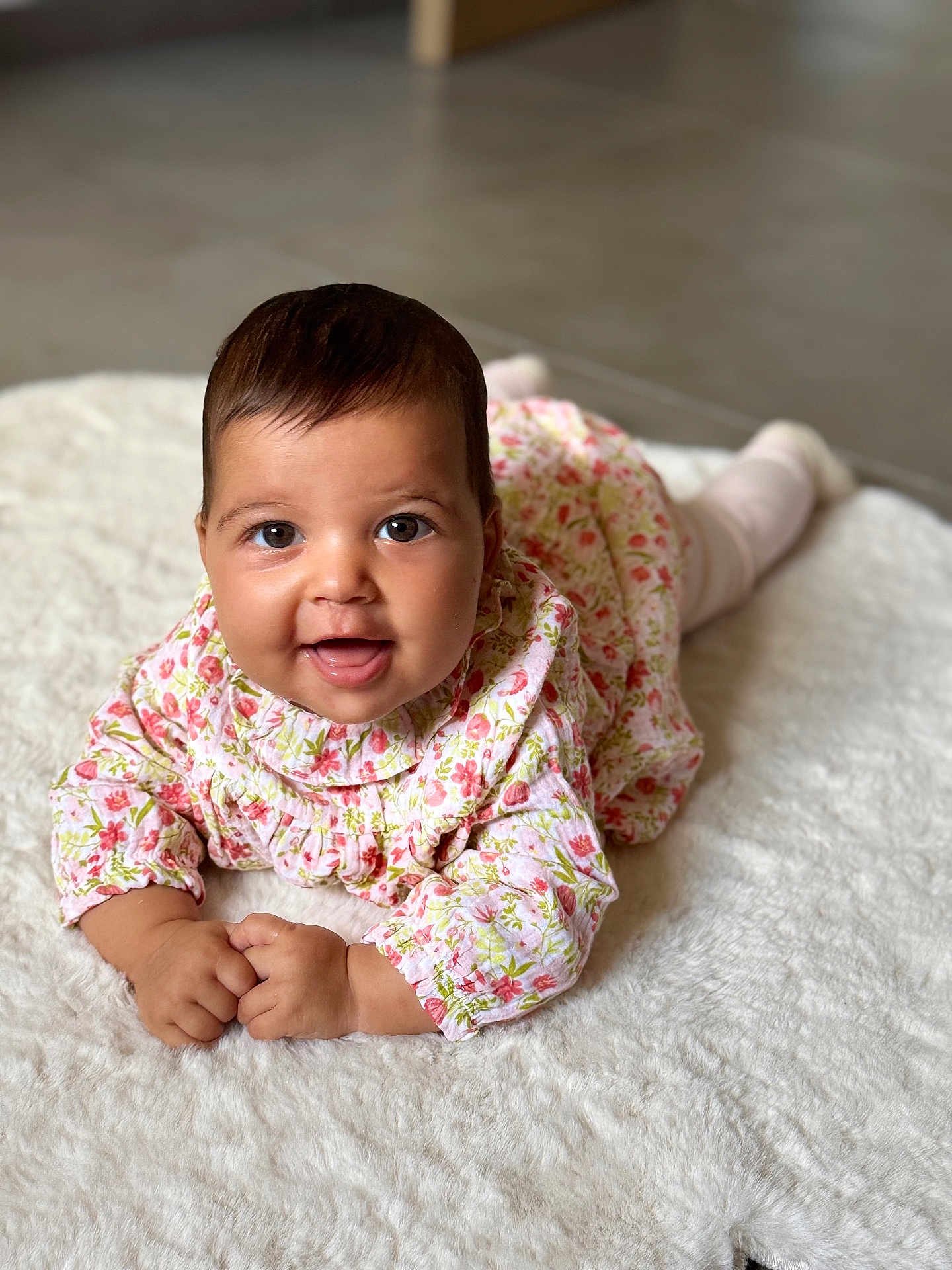 Charlie a rejoint le concours — aidez-le/la à gagner de superbes lots ! baby, infant, smiling, face, eyes, hands, floral_dress, white_rug, crawling, cute, child, portrait, indoors, soft_texture, happy, young, person, skin, head, expression