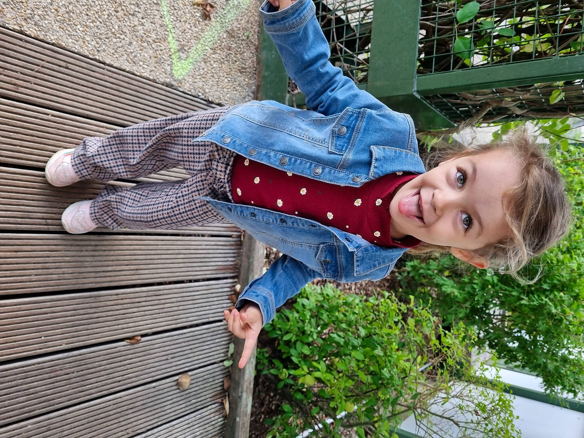Arya a rejoint le concours — aidez-le/la à gagner de superbes lots ! carmine, child, denim, electric_blue, fun, grass, happy, leisure, pattern, people_in_nature, person, plaid, plant, portrait_photography, sitting, sleeve, smile, toddler, wood
