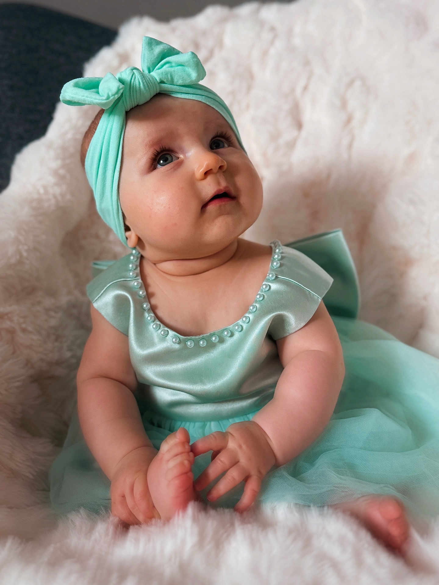 Lyana a rejoint le concours — aidez-le/la à gagner de superbes lots ! baby, child, mint_green, dress, headband, bow, pearl, fluffy_blanket, sitting, curious, cute, portrait, infant, chubby_cheeks, soft_texture, indoors, hands, feet, looking_up, skin