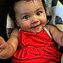 arm, baby, baby_girl, child, clothing, curly_hair, cushion, cute, eyes, face, happy, indoor, infant, person, portrait, red_dress, seat, skin, smiling, watermelon_pattern