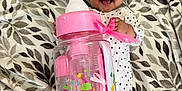 Victoria is registered to the contest to win money with this photo: baby, smiling, blanket, leaf_pattern, onesie, polka_dots, toy, pink, bottle, cute, infant, happy, lying_down, face, child, comfort, playful, room, soft, accessory