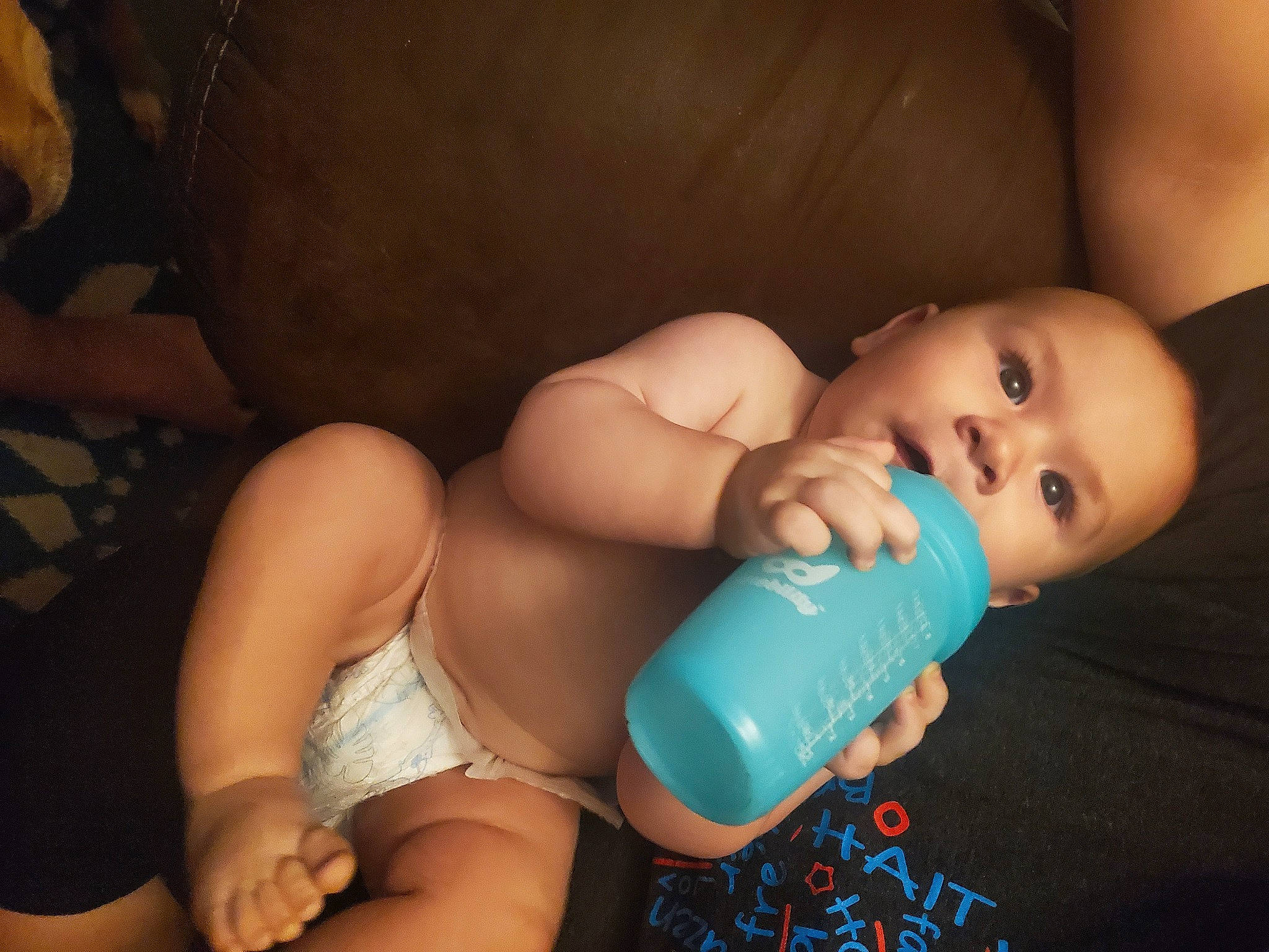 William is registered to the contest to win money with this photo: arm, baby, baby_bottle, cheek, comfort, drinkware, eye, eyelash, finger, flash_photography, iris, joint, leg, mouth, nail, person, plastic_bottle, skin, thigh, thumb