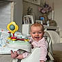 baby, infant, smile, tongue_out, striped_clothing, baby_seat, toy, play, happy, child, indoor, carpet, foot, hand, face, person, living_room, furniture, decor, photography