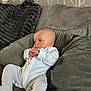 baby, infant, couch, pillow, onesie, striped_clothing, indoor, soft_furniture, seated, portrait, young_child, curious, cozy, head, hands, face, relaxing, home, child, comfort