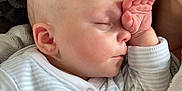 Renson joined the competition — help win amazing prizes! baby, sleeping, hand, face, onesie, striped_clothing, blanket, soft_texture, cozy, infant, peaceful, closeup, skin, ear, nap, child, person, resting, indoors, portrait