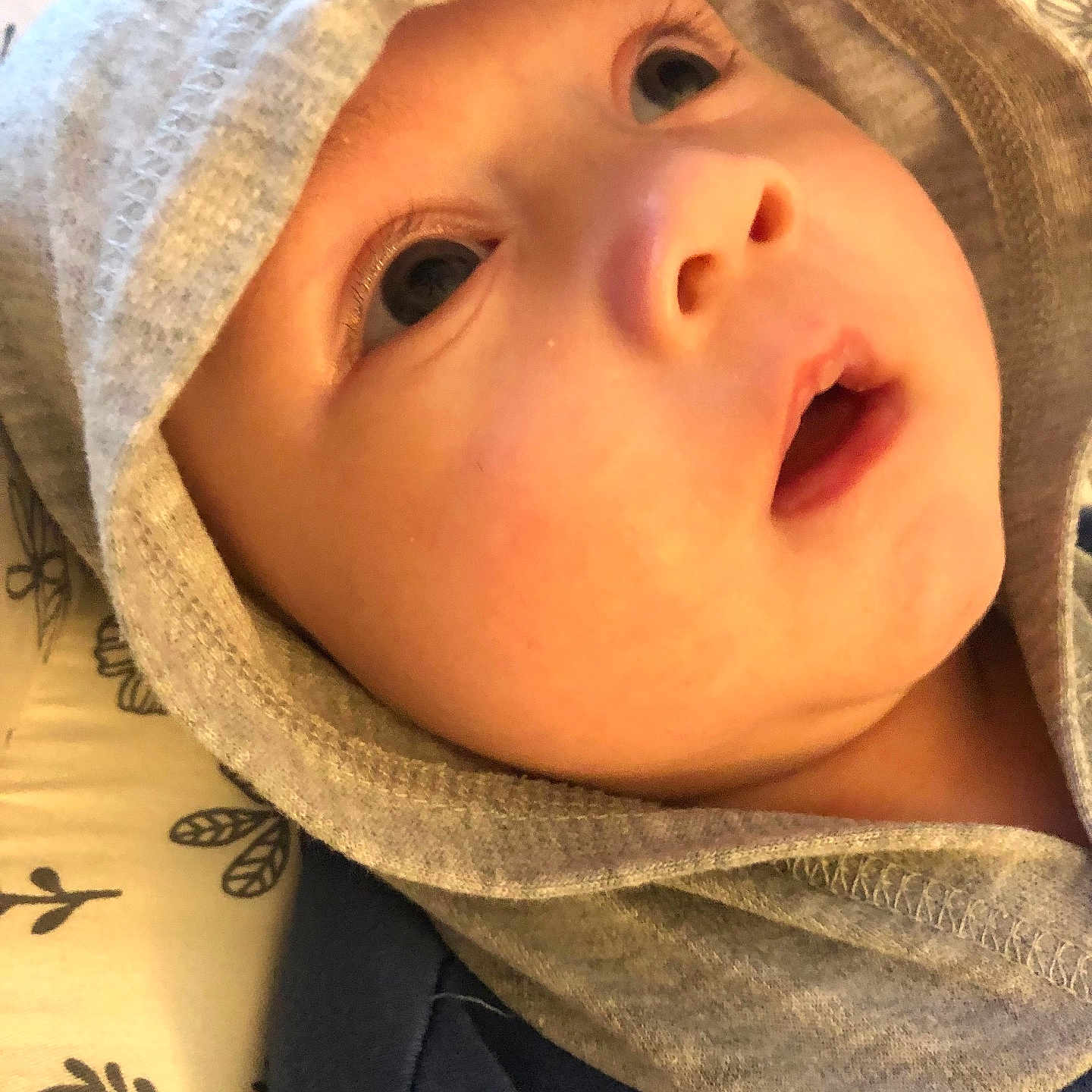 Liam Ryker is registered to the contest to win money with this photo: baby, blanket, child, closeup, clothing, cute, expression, eyes, fabric, face, headwear, hood, infant, laying, mouth, newborn, pattern, portrait, skin, soft