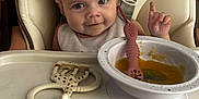 Mia participe au concours pour gagner de l'argent avec cette photo : baby, bib, child, cute, expression, face, feeding, food, giraffe_toy, high_chair, indoor, infant, messy, person, seat, smile, spoon, table, teething_toy, tray