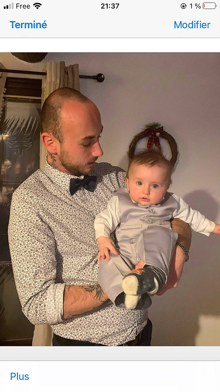 Lino participe au concours pour gagner de l'argent avec cette photo : baby, baby_toddler_clothing, beard, chair, cheek, child, comfort, ear, event, family, fun, gesture, hairstyle, happy, lap, person, personal_protective_equipment, room, sitting, sleeve