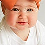 baby, child, bow, headband, orange, white_clothing, crawling, face, cheeks, eyes, smile, infant, cute, portrait, headwear, baby_girl, expression, indoors, soft_light, closeup