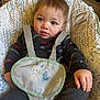 Julian is registered to the contest to win money with this photo: baby, toddler, child, seat, baby_seat, straps, clothing, patterned, face, hand, curious, blue_eyes, indoors, floor, warning_label, expression, cute, casual, comfort, young