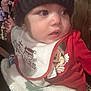 Julian is registered to the contest to win money with this photo: baby, child, hat, knit_hat, bib, mickey_mouse, red_clothing, blanket, holiday, christmas, indoor, face, expression, cute, curious, person, young_child, festive, warm_clothing, crowd