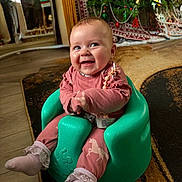 Evelyne joined the competition — help win amazing prizes! baby, smiling, pink_clothing, baby_seat, indoor, christmas_tree, festive, carpet, happy, child, floor, holiday_decor, seat_belt, socks, cute, infant, decorations, lacy_socks, holiday, home