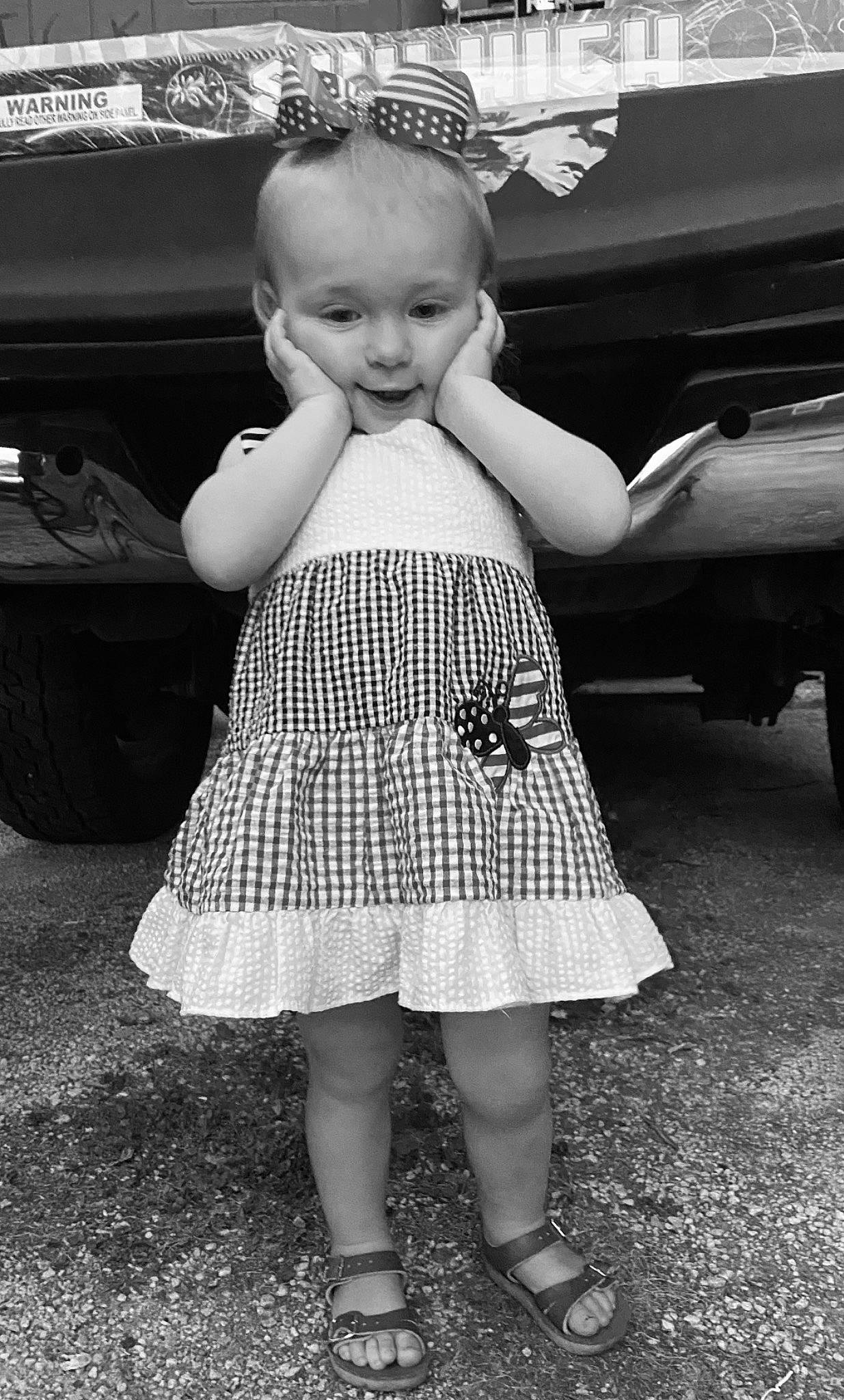 Hazley is registered to the contest to win money with this photo: black, black_and_white, dress, facial_expression, finger, flash_photography, gesture, happy, head, human_body, one_piece_garment, people_in_nature, person, photograph, product, shoe, skin, standing, style, toddler