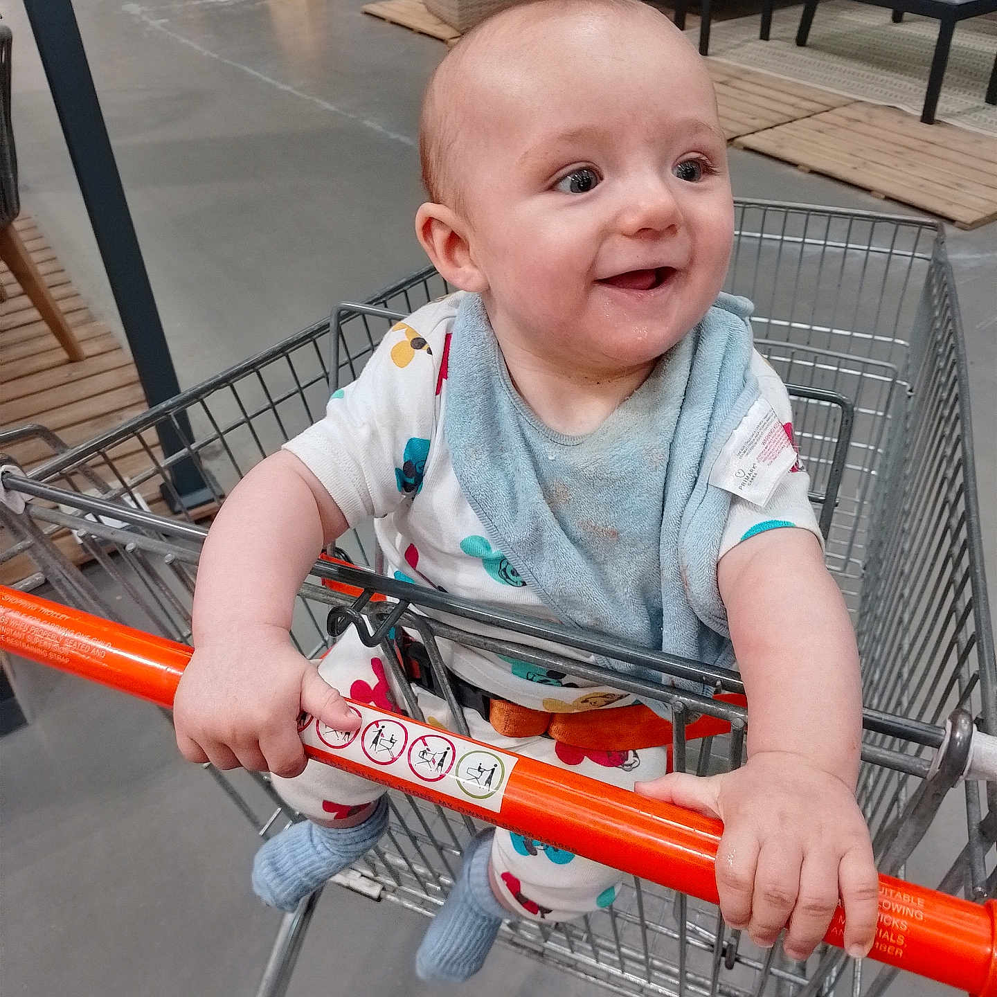 James joined the competition — help win amazing prizes! baby, bib, child, clothing, cute, floor, footwear, furniture, hand, happy, indoor, infant, person, retail, seat, shopping, shopping_cart, smiling, sock, store