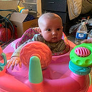 Lillianna joined the competition — help win amazing prizes! baby, bottle, box, child, clothing, container, curious, expression, face, floor, furniture, hand, indoor, person, pink, plastic, seat, storage, toy, walker