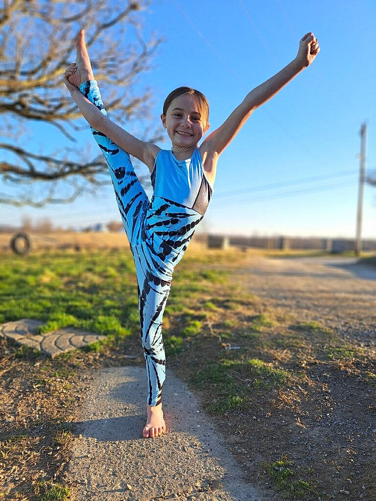 Skylah is registered to the contest to win money with this photo: electric_blue, exercise, face, flash_photography, fun, gesture, grass, grassland, happy, human_leg, joy, leisure, people_in_nature, person, plant, recreation, running, sky, smile, sportswear