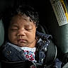 baby, black_hair, button, car_seat, child, child_safety, close_up, cute, denim_jacket, fabric, floral_clothing, indoors, infant, peaceful, portrait, resting, seat, seat_belt, sleeping, young_child
