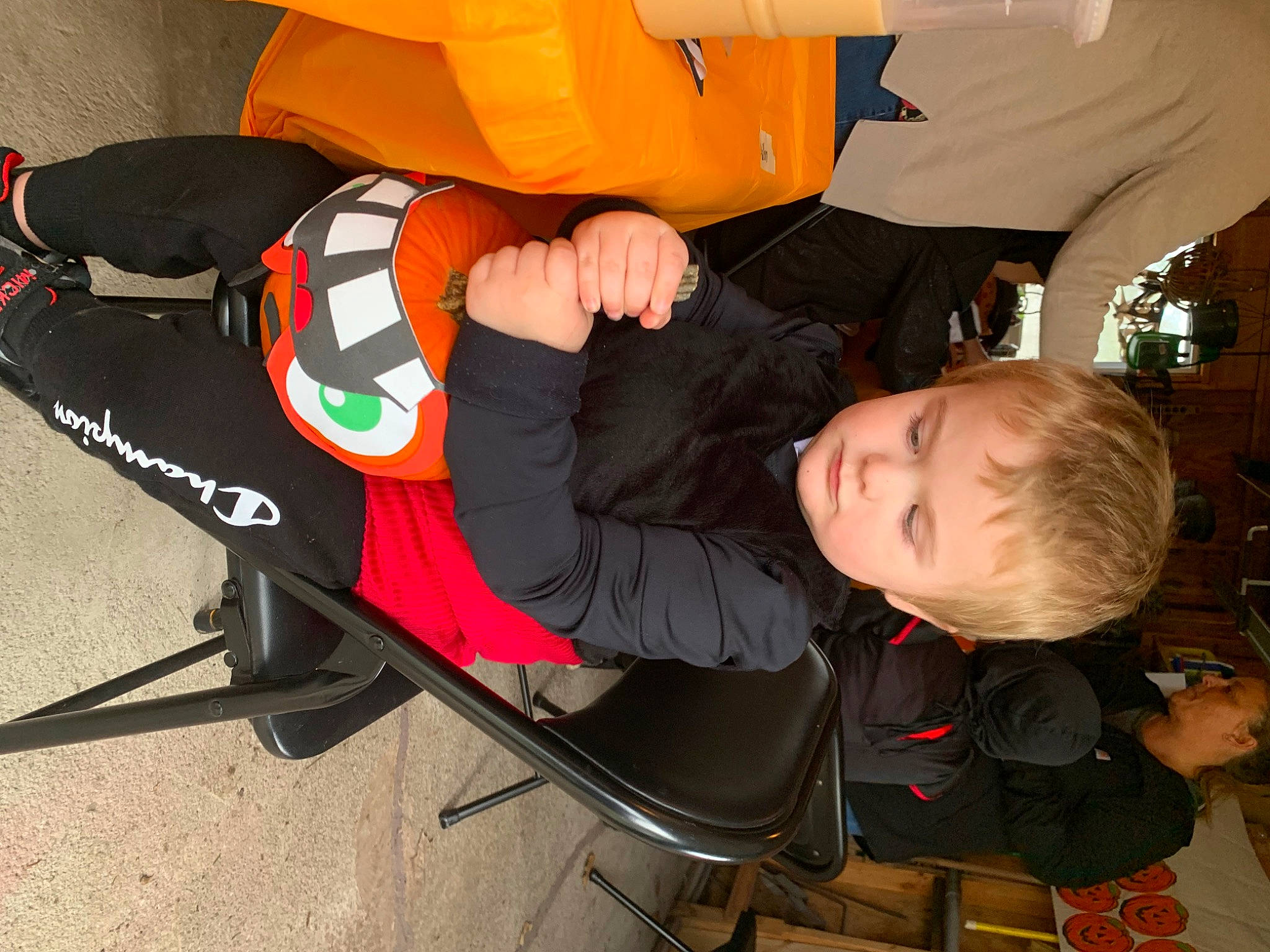 Kallen is registered to the contest to win money with this photo: auto_part, baby_products, chair, comfort, fun, lap, luggage_and_bags, orange, person, personal_protective_equipment, recreation, tire, toddler, wheel
