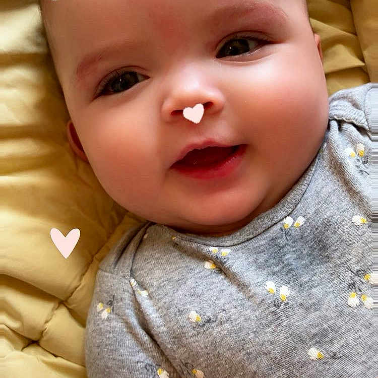 Eille is registered to the contest to win money with this photo: accessories, baby, babylaughing, blonde, clothing, cushion, face, happy, head, homedecor, newborn, number, person, photography, portrait, quilt, smile, symbol, t_shirt, text