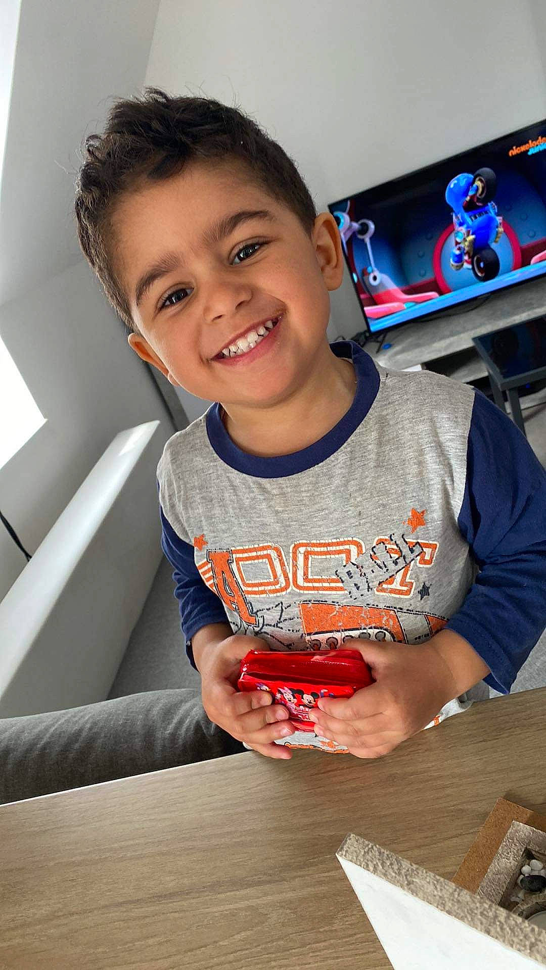 Ezel participe au concours pour gagner de l'argent avec cette photo : carmine, child, cool, finger, flash_photography, fun, gadget, gesture, hand, happy, joy, leisure, person, recreation, sitting, smile, t_shirt, table, tableware, thumb