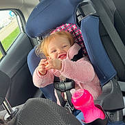 Coralyn is registered to the contest to win money with this photo: toddler, child, car_seat, car_interior, pink_jacket, smiling, sippy_cup, seatbelt, window, car_door, headrest, seat, happy, young_child, safety_harness, vehicle, daylight, casual_clothing, cute, travel