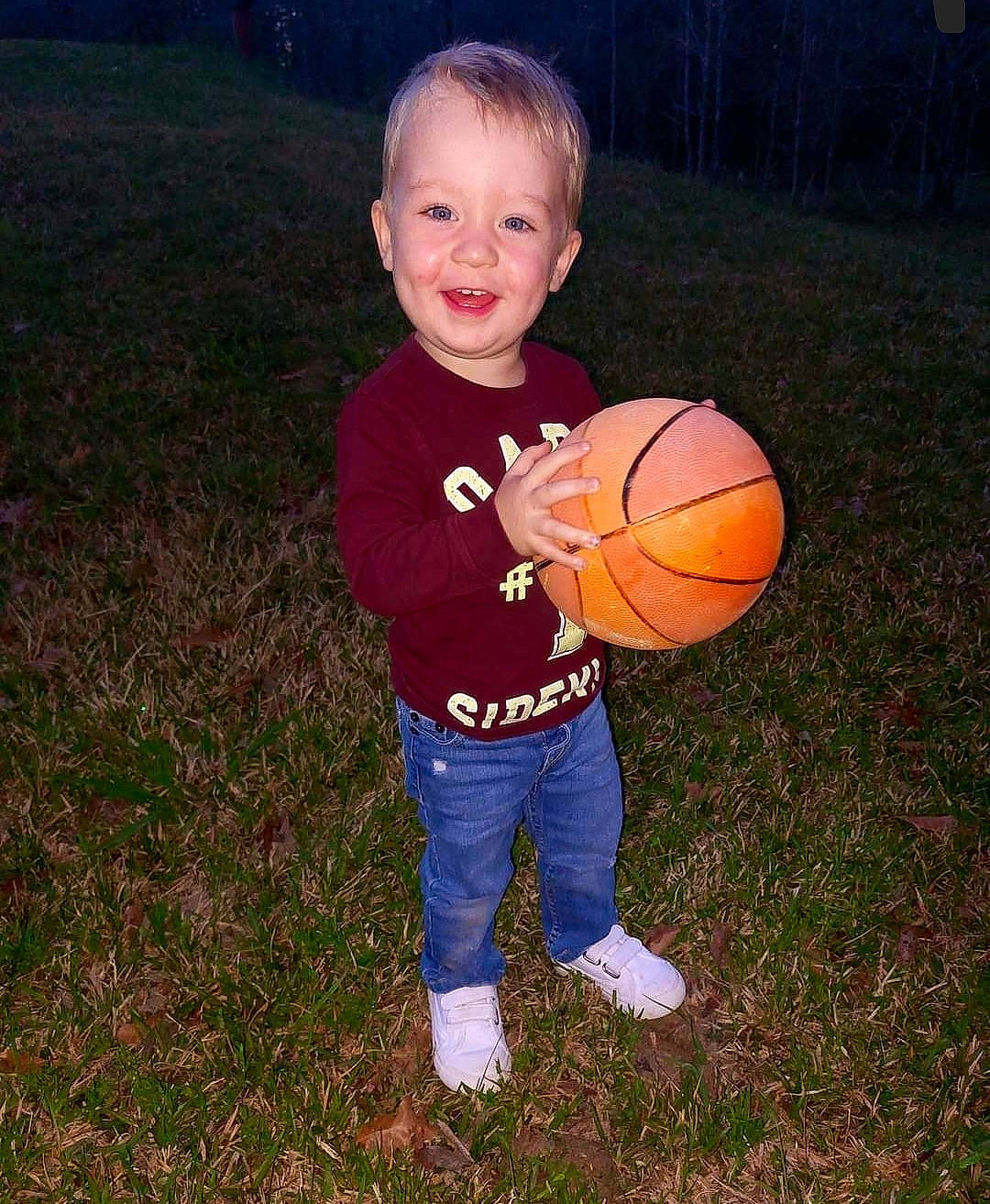 Logan joined the competition — help win amazing prizes! ball, basketball, child, flash_photography, football, fun, gesture, grass, happy, joy, people_in_nature, person, plant, play, sitting, smile, soccer_ball, sports_equipment, sports_toy, t_shirt