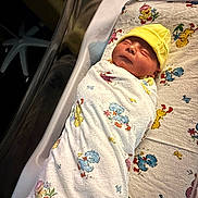 Haze joined the competition — help win amazing prizes! newborn, baby, swaddled, blanket, yellow_hat, sleeping, hospital, bassinet, infant, peaceful, cute, child, person, resting, soft_lighting, duck_pattern, bed, maternity, newborn_care, cozy