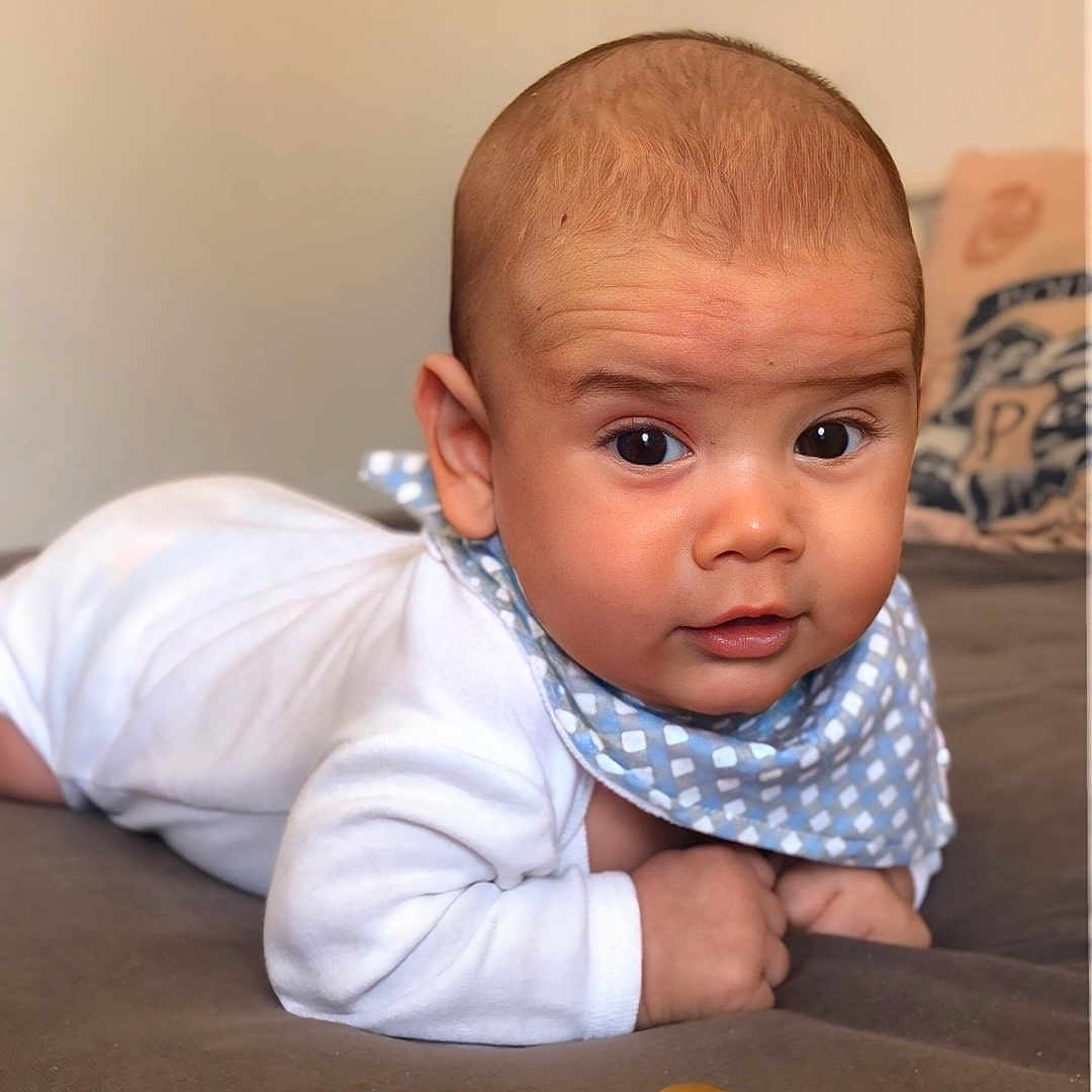 Damian participe au concours pour gagner de l'argent avec cette photo : baby, bed, bib, child, closeup, curious, cute, expression, face, hands, head, indoor, infant, lying_down, pacifier, portrait, skin, soft_surface, white_clothing, young