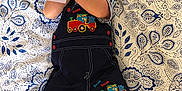 Damian a rejoint le concours — aidez-le/la à gagner de superbes lots ! baby, infant, child, overalls, patterned_blanket, blue_socks, train_patch, holding_card, text_card, lying_down, cute, smiling, happy, indoor, fabric, clothing, face, head, hand, feet