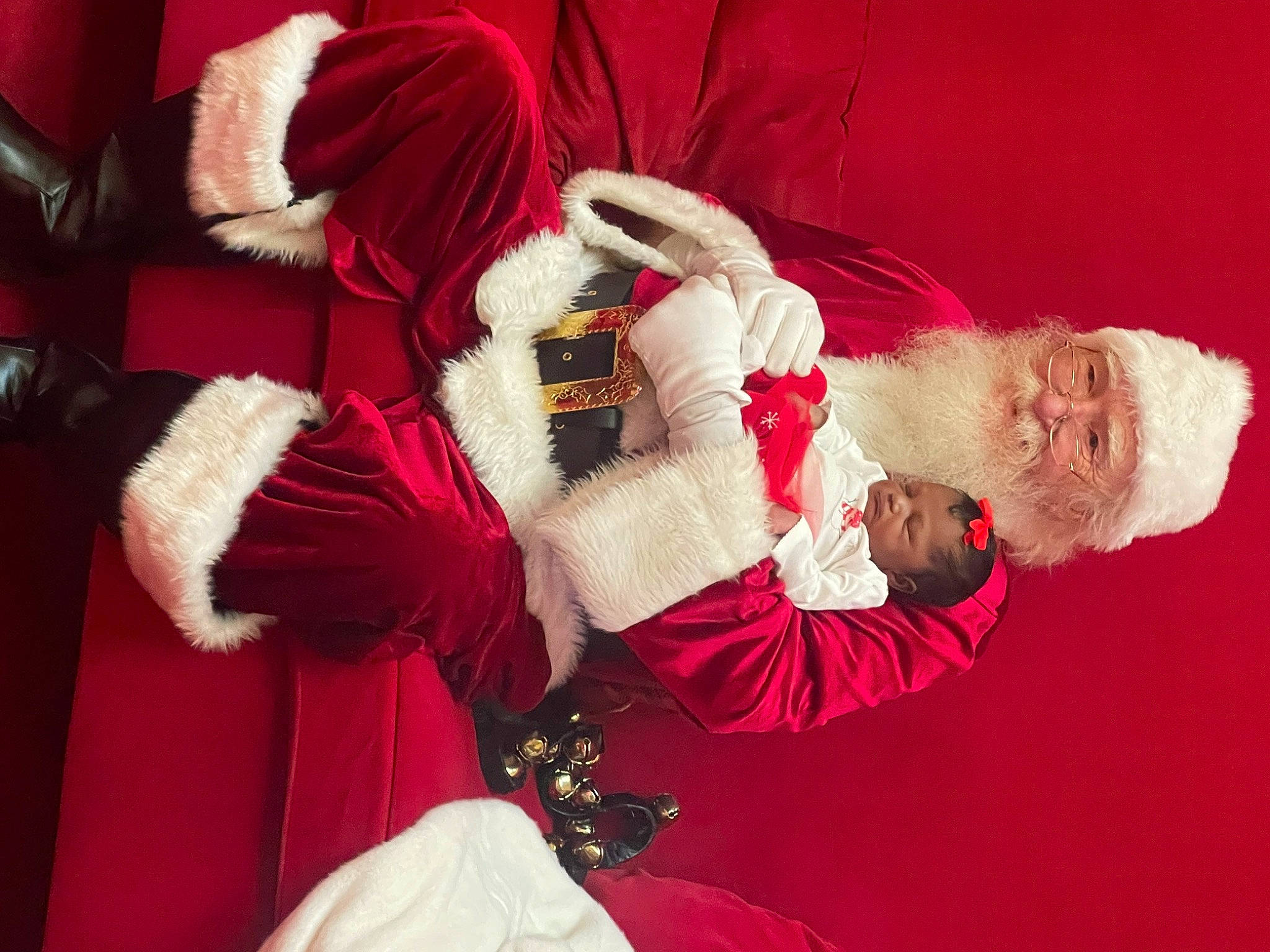 Bella is registered to the contest to win money with this photo: carmine, christmas, christmas_eve, comfort, costume, dress, event, fictional_character, fur, fur_clothing, gesture, happy, holiday, lap, linens, magenta, person, santa_claus, sitting, tradition