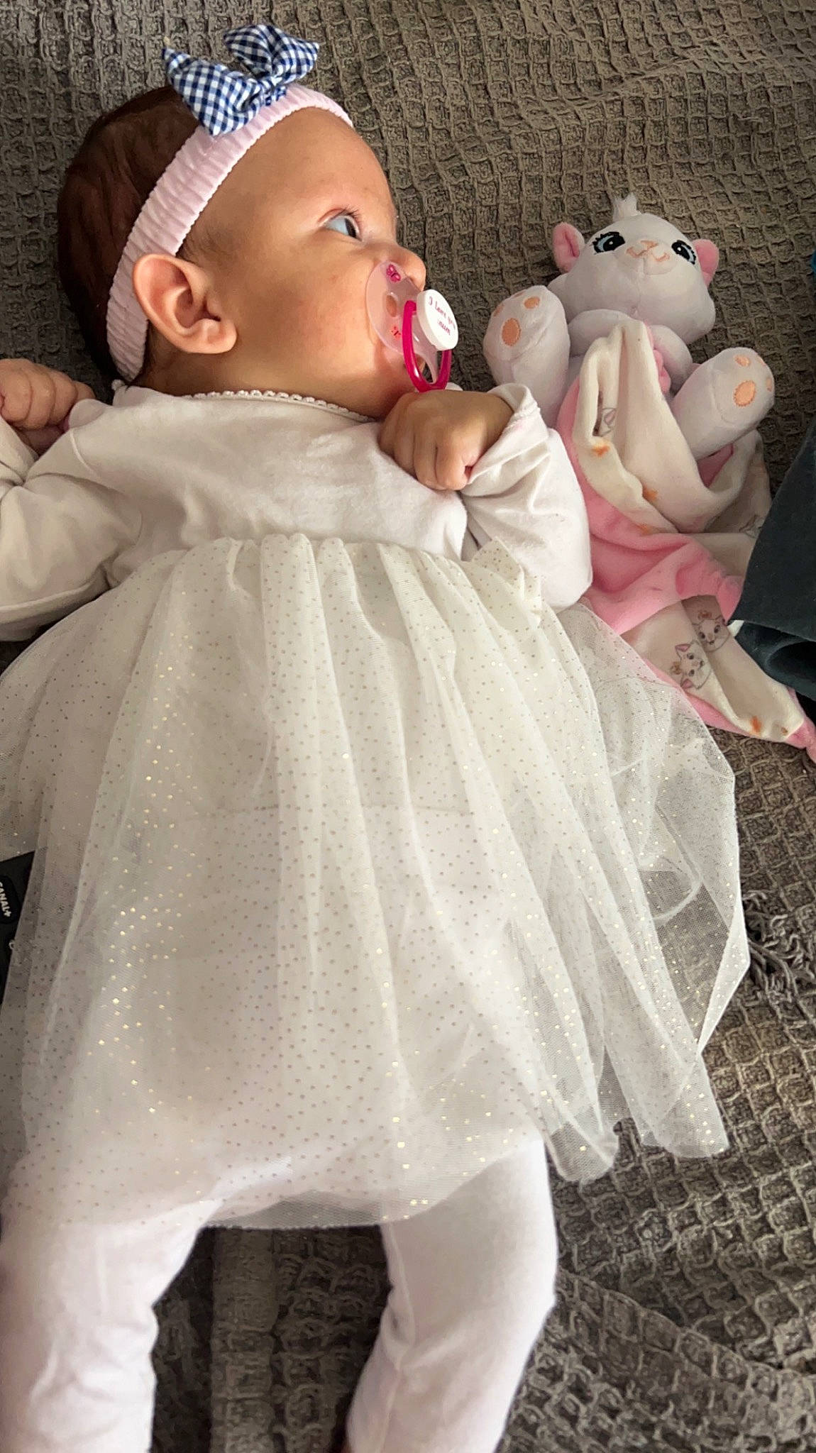 Maria participe au concours pour gagner de l'argent avec cette photo : arm, baby, baby_toddler_clothing, cap, cheek, dress, eye, face, finger, hand, head, headgear, human_body, lip, person, photograph, pink, skin, sleeve, textile