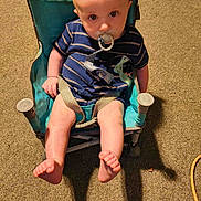 Conan joined the competition — help win amazing prizes! baby, pacifier, child, chair, striped_clothing, blue_clothing, dinosaur_patch, carpet, indoor, dog_paws, small_chair, seated, looking_up, curious, infant, cute, legs, feet, shadow, comfort