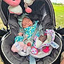 baby, car_seat, sleeping, toy, plush, headband, outdoor, greenery, blanket, infant, safety_harness, child, cute, peaceful, comfort, seat, fabric, nature, soft, rest