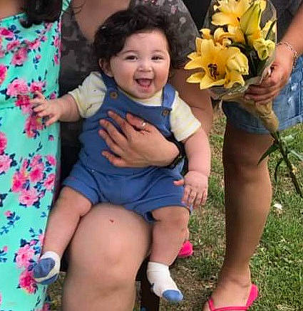 Marcus is registered to the contest to win money with this photo: baby_toddler_clothing, child, electric_blue, event, flower, flower_arranging, fun, grass, happy, human_leg, leg, leisure, people_in_nature, person, petal, plant, shorts, sitting, smile, thigh