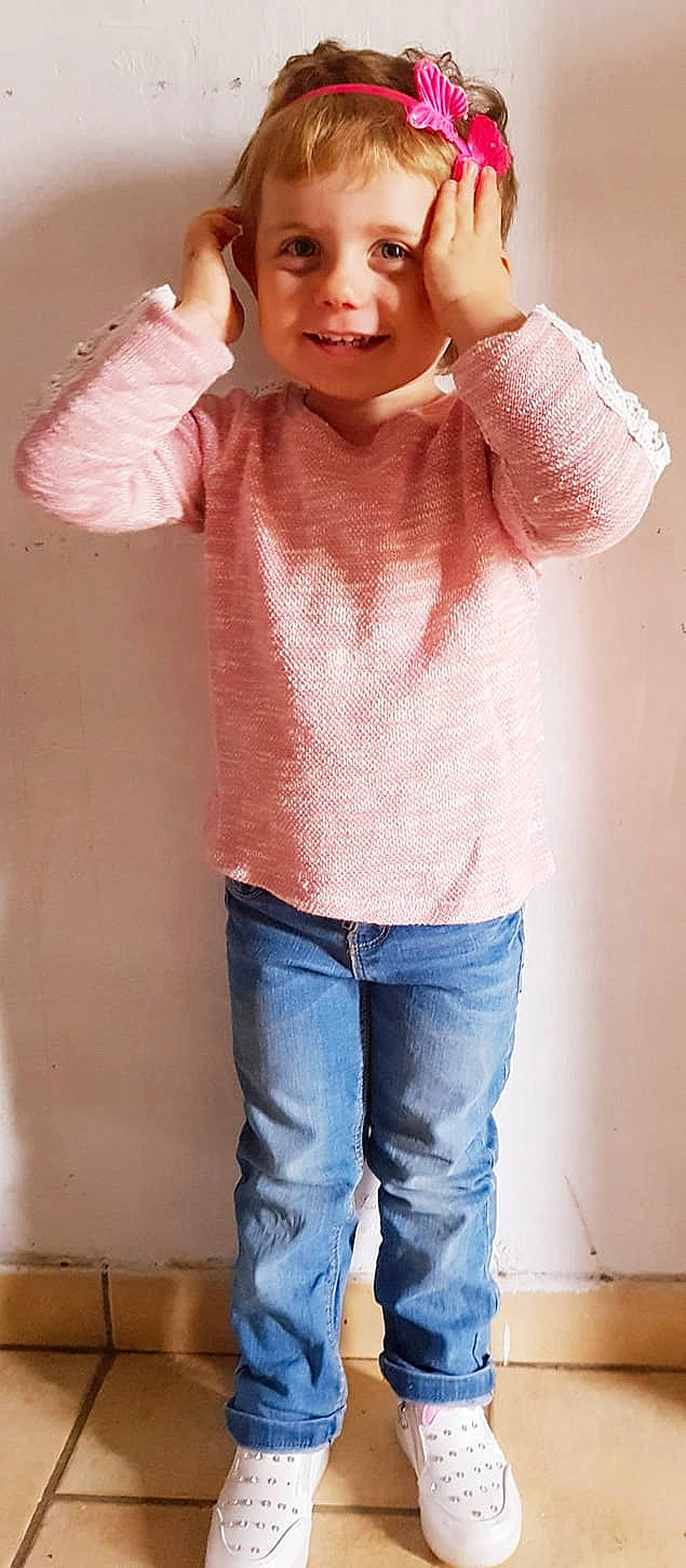 Violette participe au concours pour gagner de l'argent avec cette photo : arm, blond, child_model, clothing, cool, denim, fun, gesture, jeans, joint, joy, muscle, neck, outerwear, person, pink, shoulder, sleeve, standing, sweater