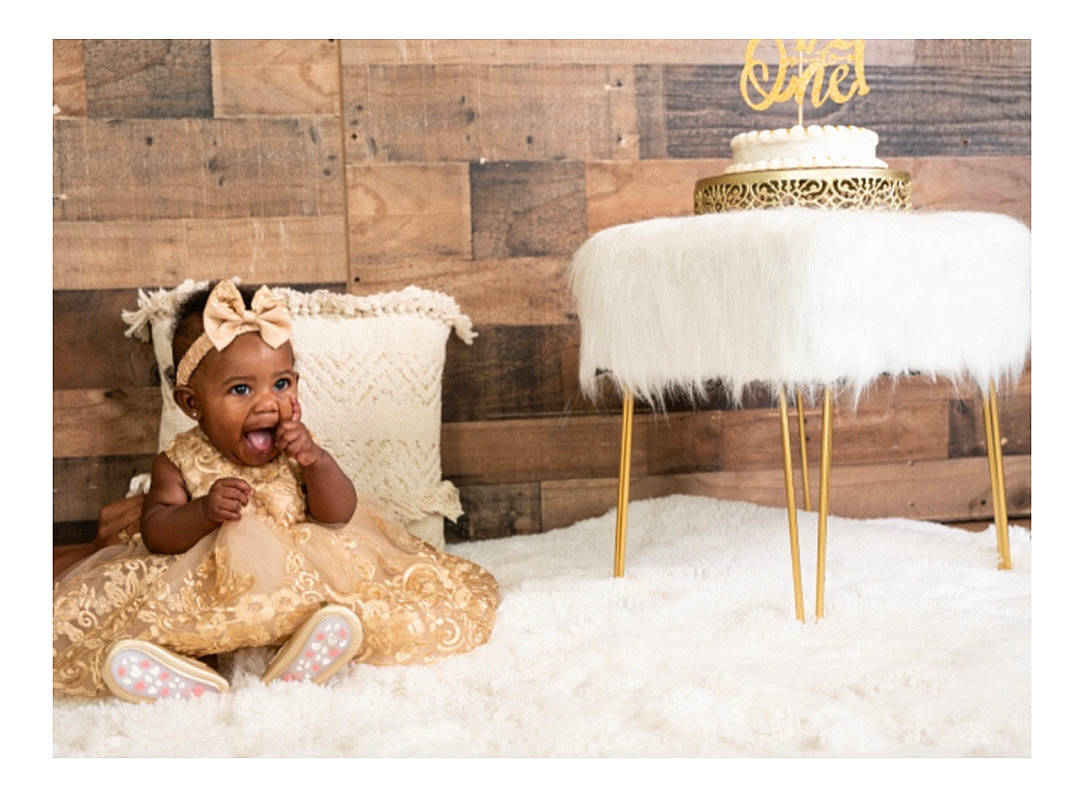 Hiraani is registered to the contest to win money with this photo: art, baby, chair, child, comfort, fashion_accessory, flooring, font, fur, happy, headwear, illustration, linens, person, rectangle, room, sitting, smile, textile, throw_pillow