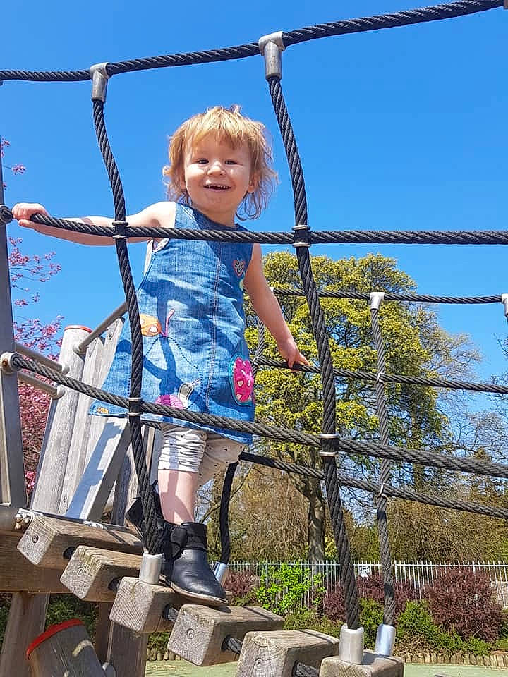 Aria-rose is registered to the contest to win money with this photo: child, city, fun, human_settlement, joy, leisure, outdoor_play_equipment, person, plant, playground, public_space, recreation, sky, smile, toddler, tree, vacation