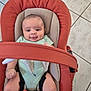 baby, baby_carrier, baby_clothing, baby_expression, baby_face, baby_gesture, baby_hands, baby_legs, baby_pose, baby_rocker, baby_safety, baby_seat, baby_smile, child, floor_tiles, indoor, infant, onesie, seatbelt, tiled_floor
