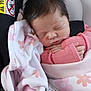 newborn, baby, sleeping, blanket, pink_clothing, car_seat, infant, face, hand, hair, safety_label, soft_texture, cute, child, resting, indoors, closeup, peaceful, wrapped, portrait