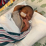 Hezekiah joined the competition — help win amazing prizes! newborn, baby, infant, sleeping, crib, blanket, swaddle, pajamas, face, bandage, pacifier, nursery, bedding, football, patterned, cozy, indoors, portrait, resting, child