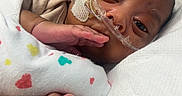 Hezekiah joined the competition — help win amazing prizes! newborn, baby, infant, child, hospital, bassinet, blanket, swaddle, medical_equipment, nasal_tube, hospital_gown, lying_down, portrait, face, eyes_open, hand, feet, toes, indoor, care